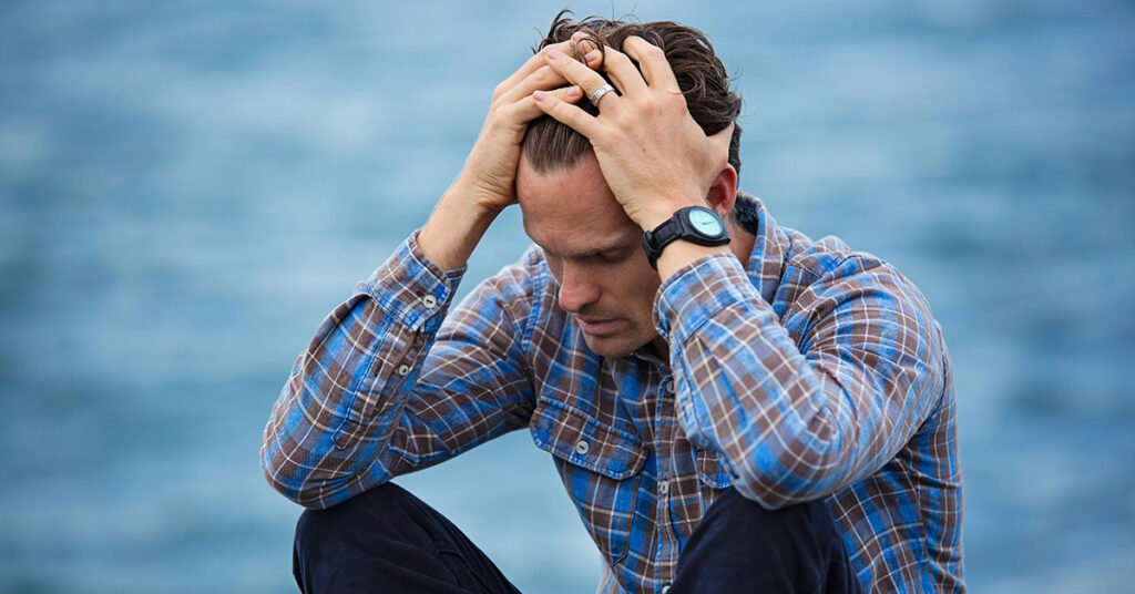 Tired man sitting with low energy and mental fatigue - Mitolyn